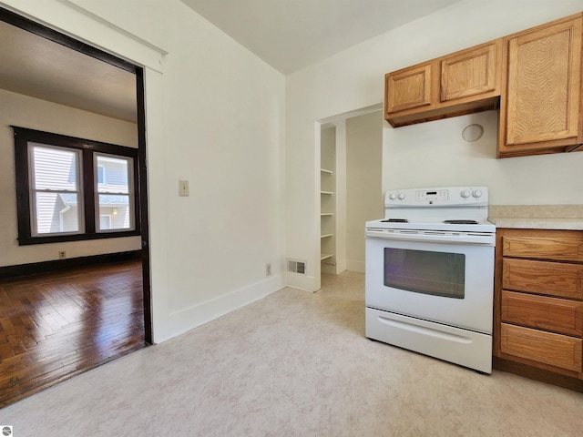 kitchen featuring electric stove, light countertops, baseboards, and brown cabinets