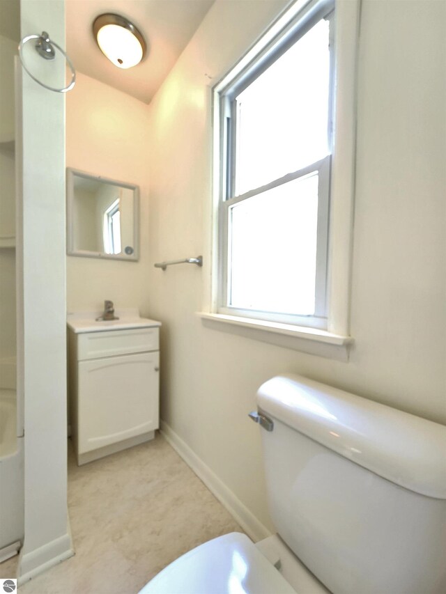 full bathroom featuring plenty of natural light, toilet, baseboards, and vanity