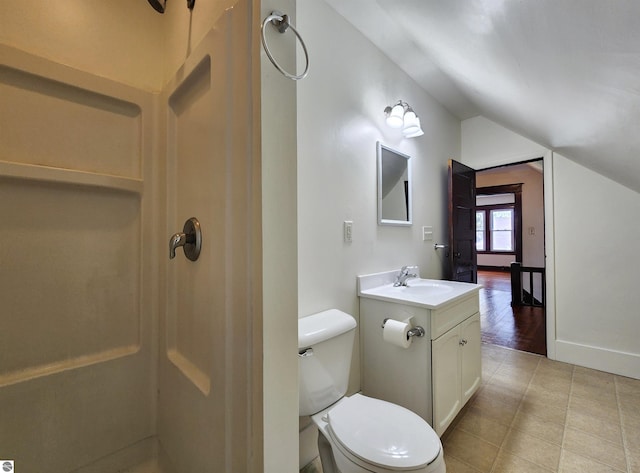 bathroom featuring vaulted ceiling, a shower, vanity, toilet, and tile patterned floors