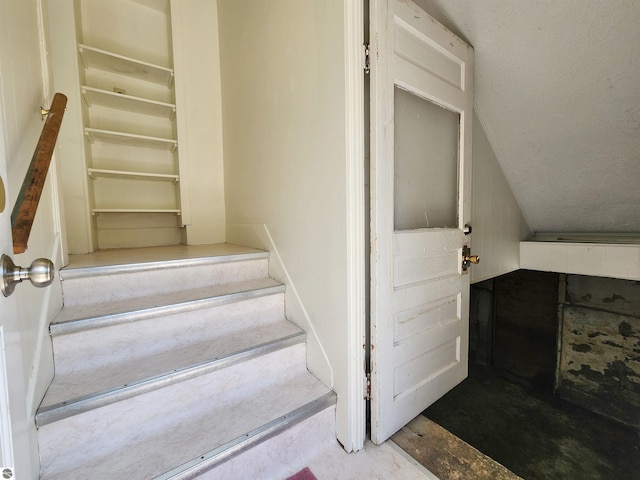stairs featuring unfinished concrete floors