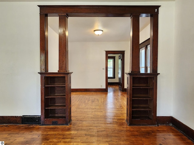 hallway featuring hardwood / wood-style flooring and baseboards