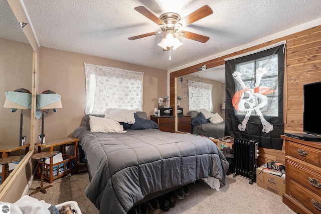 1956 S Goldenrod, Lake City, MI 49651 - bedroom with multiple windows, carpet flooring, radiator heating unit, wood walls, and a textured ceiling