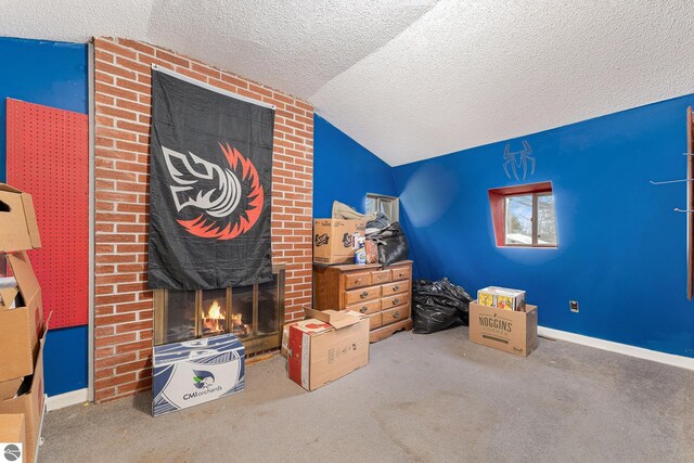 1956 S Goldenrod, Lake City, MI 49651 - bedroom featuring a textured ceiling, carpet flooring, a fireplace, and lofted ceiling