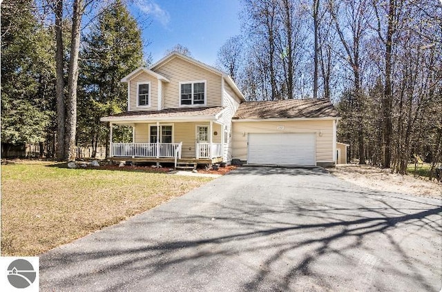 8565 Bent Pine Dr, Lake Ann, MI 49650 - view of front of home featuring asphalt driveway, covered porch, a garage, and a front lawn