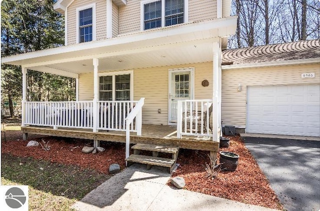 8565 Bent Pine Dr, Lake Ann, MI 49650 - view of exterior entry featuring covered porch and a garage