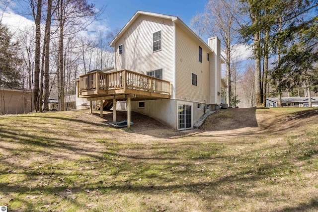 8565 Bent Pine Dr, Lake Ann, MI 49650 - rear view of property with a deck, a chimney, a yard, and central AC unit