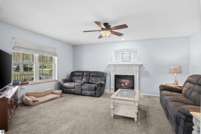 8565 Bent Pine Dr, Lake Ann, MI 49650 - living area featuring a ceiling fan, carpet floors, a glass covered fireplace, and baseboards