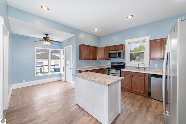 117 S Fancher St, Mount Pleasant, MI 48858 - kitchen with appliances with stainless steel finishes, brown cabinetry, light wood-style flooring, and recessed lighting