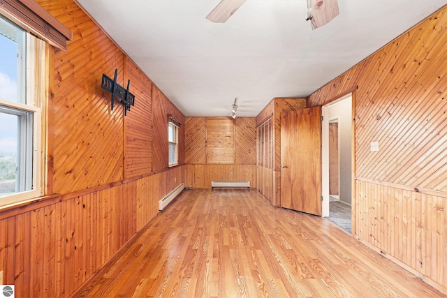 4120 M-66, Kalkaska, MI 49646 - additional living space with a baseboard heating unit, wood walls, light wood-style flooring, and ceiling fan