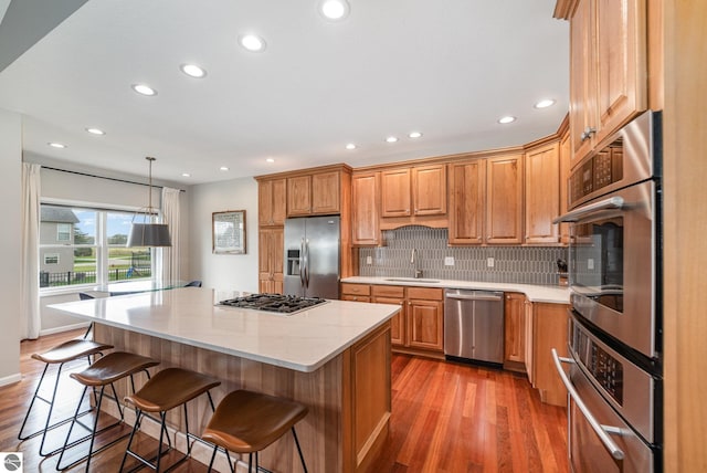 726 Doe Trl, Mount Pleasant, MI 48858 - kitchen featuring stainless steel appliances, a sink, recessed lighting, decorative backsplash, and a breakfast bar area