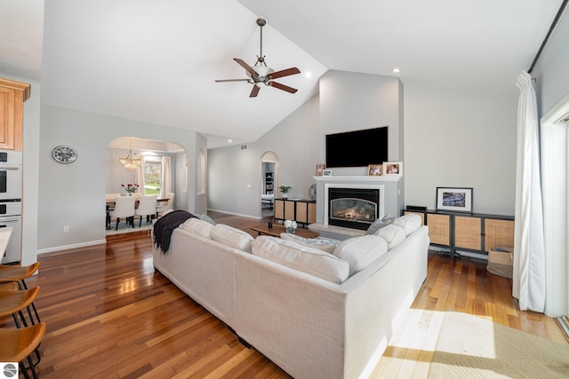 726 Doe Trl, Mount Pleasant, MI 48858 - living area featuring arched walkways, ceiling fan, light wood-type flooring, a glass covered fireplace, and high vaulted ceiling