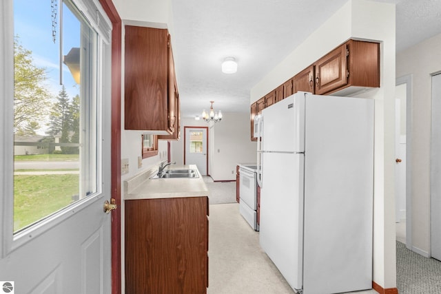 203 W Sixteenth St, Traverse City, MI 49684 - kitchen featuring white appliances, a sink, a chandelier, light colored carpet, and light countertops