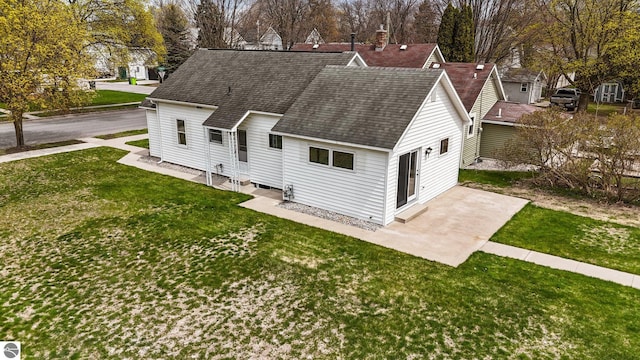 203 W Sixteenth St, Traverse City, MI 49684 - view of front of home with roof with shingles, a front lawn, a patio area, and entry steps
