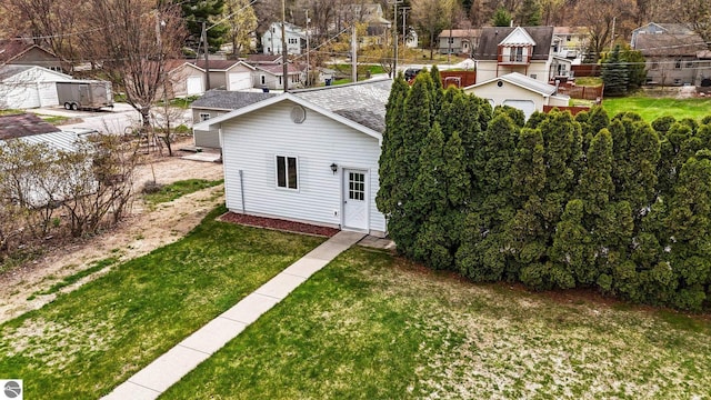203 W Sixteenth St, Traverse City, MI 49684 - view of front facade with a residential view, roof with shingles, and a front lawn