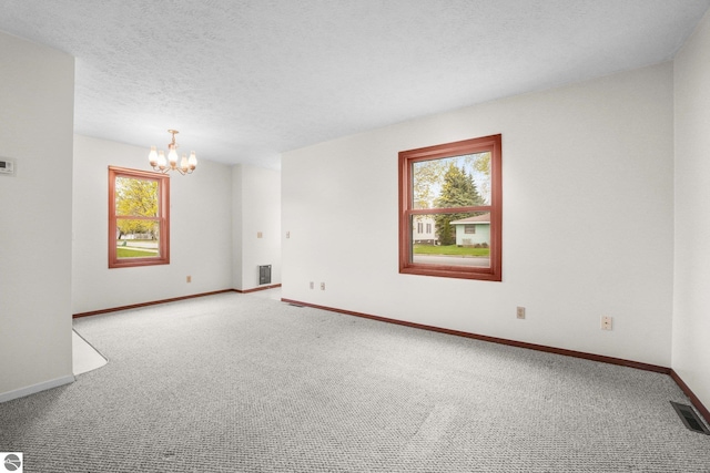 203 W Sixteenth St, Traverse City, MI 49684 - spare room featuring a chandelier, carpet floors, baseboards, and a textured ceiling