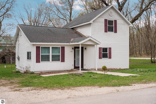 traditional-style house with roof with shingles and a front yard