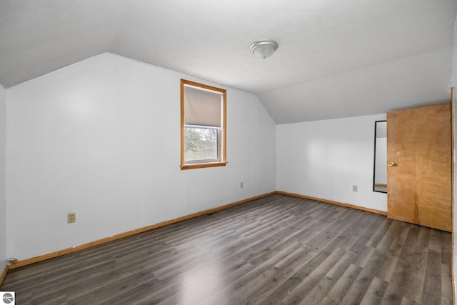 additional living space featuring vaulted ceiling, wood finished floors, and baseboards