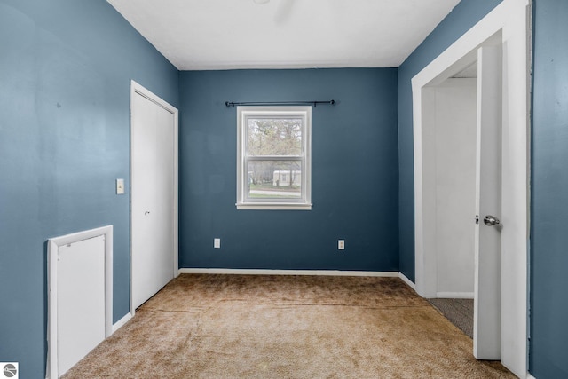 unfurnished bedroom with carpet, baseboards, and a closet