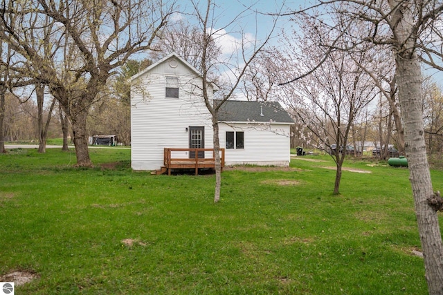rear view of property featuring a yard and a wooden deck