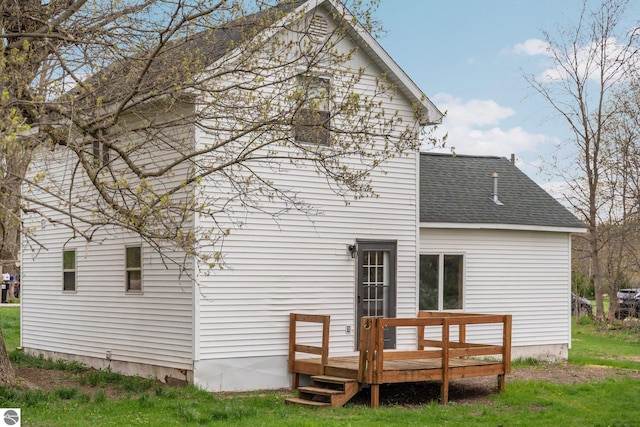 rear view of house featuring a deck and a shingled roof