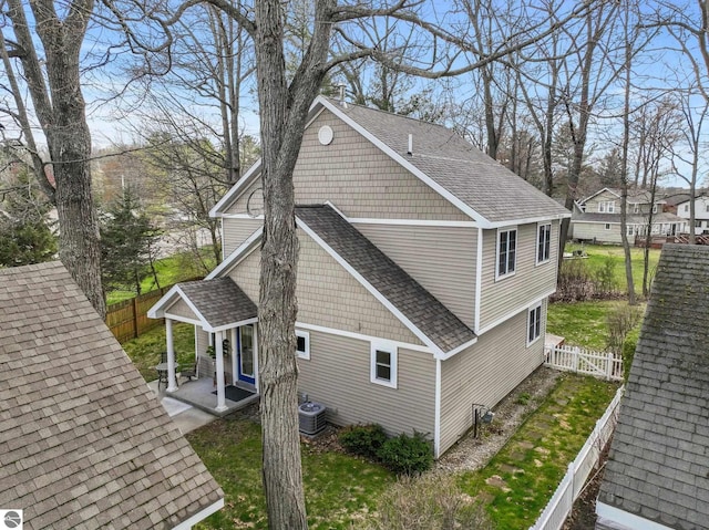 5945 E M-55, Cadillac, MI 49601 - view of home's exterior with roof with shingles, central air condition unit, a fenced backyard, and a patio