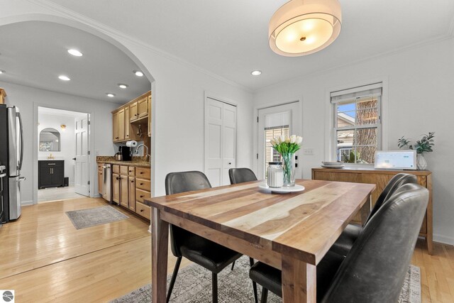 5945 E M-55, Cadillac, MI 49601 - dining area with light wood-type flooring, crown molding, arched walkways, recessed lighting, and baseboards