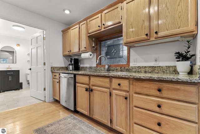 5945 E M-55, Cadillac, MI 49601 - kitchen featuring stainless steel dishwasher, a sink, light wood-style flooring, and light stone counters