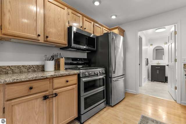 5945 E M-55, Cadillac, MI 49601 - kitchen with appliances with stainless steel finishes, light stone countertops, and light wood-style flooring