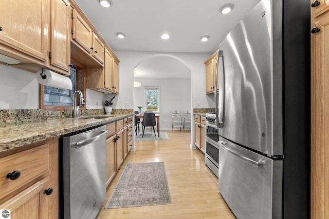 5945 E M-55, Cadillac, MI 49601 - kitchen with appliances with stainless steel finishes, arched walkways, a sink, light wood-style floors, and recessed lighting