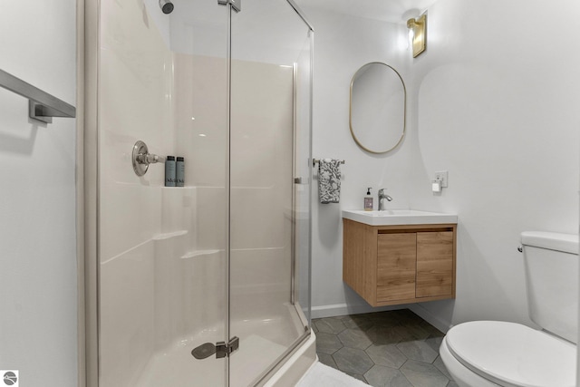 5945 E M-55, Cadillac, MI 49601 - bathroom featuring a shower stall, toilet, tile patterned flooring, vanity, and baseboards