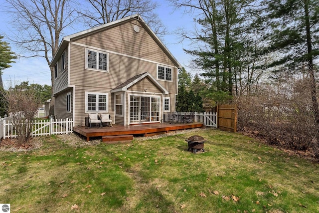 5945 E M-55, Cadillac, MI 49601 - back of property with an outdoor fire pit, a wooden deck, and a gate