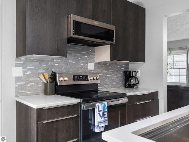 kitchen with stainless steel appliances, light countertops, a textured ceiling, and tasteful backsplash