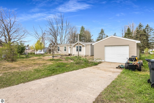 manufactured / mobile home featuring concrete driveway, a garage, and a front yard