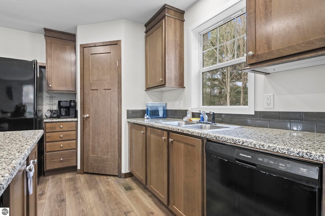 214 E N St, Buckley, MI 49620 - kitchen featuring black appliances, a sink, light wood-type flooring, and light stone counters