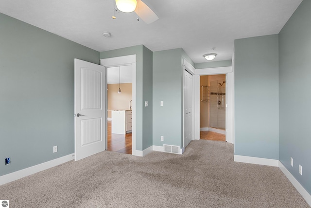 10889 Pine Bluff Dr Unit C, Traverse City, MI 49684 - unfurnished bedroom featuring carpet floors, baseboards, ceiling fan, and a closet
