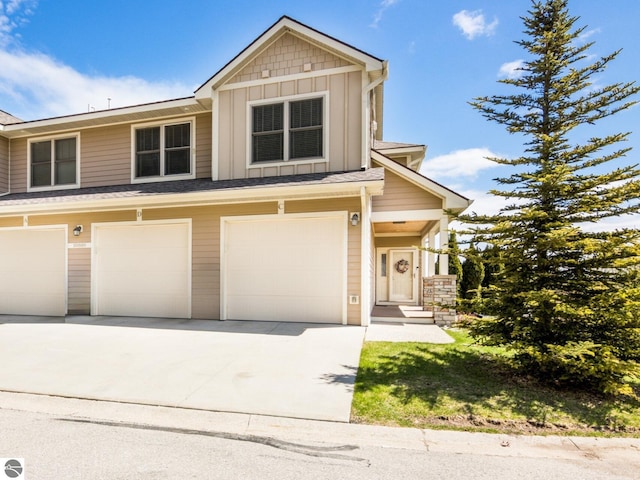 10889 Pine Bluff Dr Unit C, Traverse City, MI 49684 - multi unit property with board and batten siding, an attached garage, and driveway