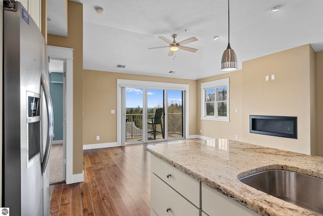10889 Pine Bluff Dr Unit C, Traverse City, MI 49684 - kitchen featuring stainless steel refrigerator with ice dispenser, open floor plan, a ceiling fan, hardwood / wood-style floors, and white cabinetry