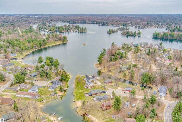 view of property location with a nearby body of water and a heavily wooded area