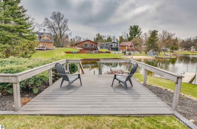 deck with a water view and a lawn
