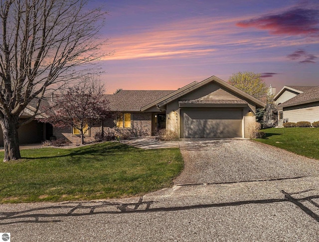 3691 Eastview Dr Unit 67, Traverse City, MI 49684 - view of front of house with driveway, a garage, a lawn, and brick siding