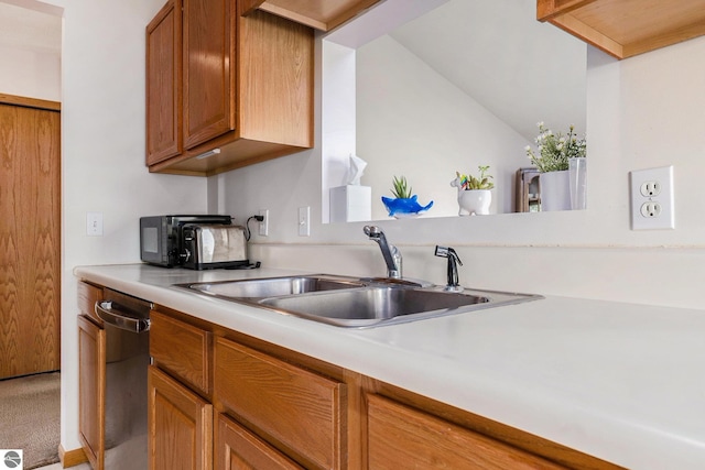 3691 Eastview Dr Unit 67, Traverse City, MI 49684 - kitchen with a sink, dishwasher, light countertops, and brown cabinets