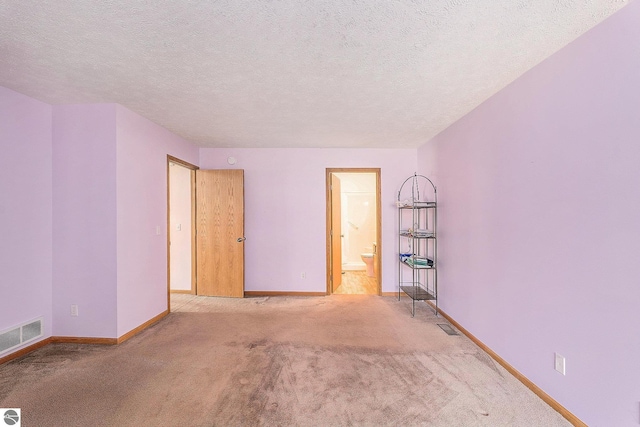 3691 Eastview Dr Unit 67, Traverse City, MI 49684 - carpeted empty room featuring baseboards and a textured ceiling