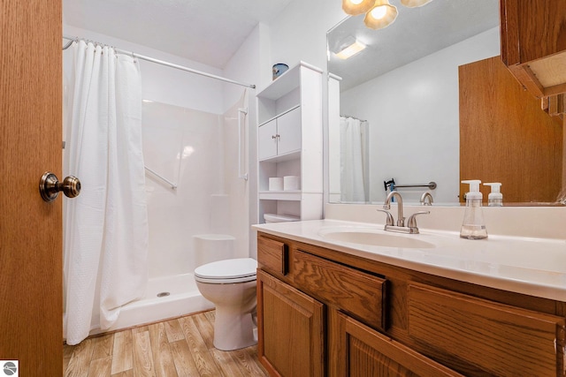 3691 Eastview Dr Unit 67, Traverse City, MI 49684 - full bath featuring wood finished floors, toilet, curtained shower, and vanity
