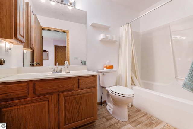 3691 Eastview Dr Unit 67, Traverse City, MI 49684 - full bathroom featuring toilet, wood finished floors, vanity, and shower / bathtub combination with curtain