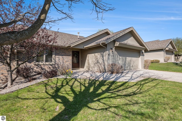 3691 Eastview Dr Unit 67, Traverse City, MI 49684 - view of front facade with an attached garage, concrete driveway, a front yard, brick siding, and a shingled roof