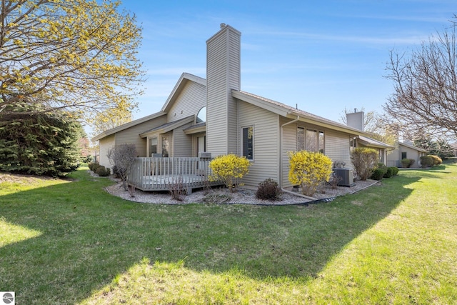 3691 Eastview Dr Unit 67, Traverse City, MI 49684 - view of side of property featuring a chimney, central AC, a yard, and a wooden deck