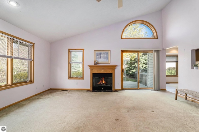 3691 Eastview Dr Unit 67, Traverse City, MI 49684 - unfurnished living room with lofted ceiling, carpet floors, a fireplace with flush hearth, baseboards, and ceiling fan