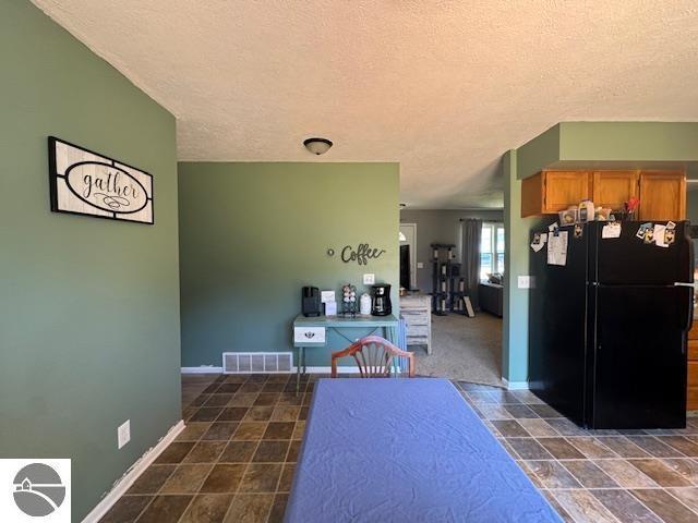 2195 S Sara Dr, Lake City, MI 49651 - dining room featuring a textured ceiling and baseboards