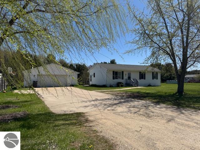 2195 S Sara Dr, Lake City, MI 49651 - view of front of home featuring an outbuilding, driveway, a front lawn, and a garage