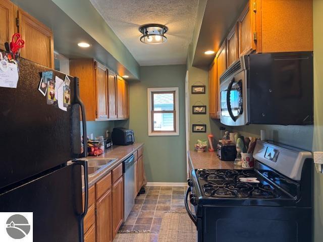 2195 S Sara Dr, Lake City, MI 49651 - kitchen with appliances with stainless steel finishes, baseboards, brown cabinets, recessed lighting, and light countertops